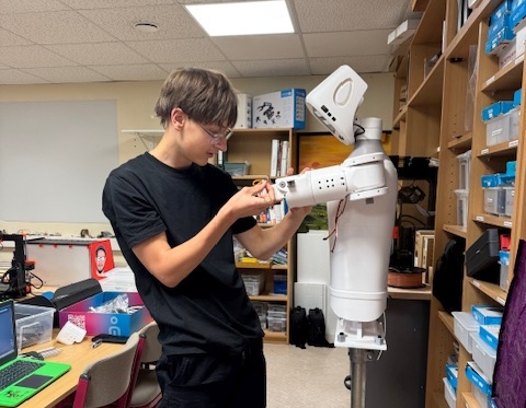 K. Häusler beim Montieren des rechten Arms am pib-Roboter